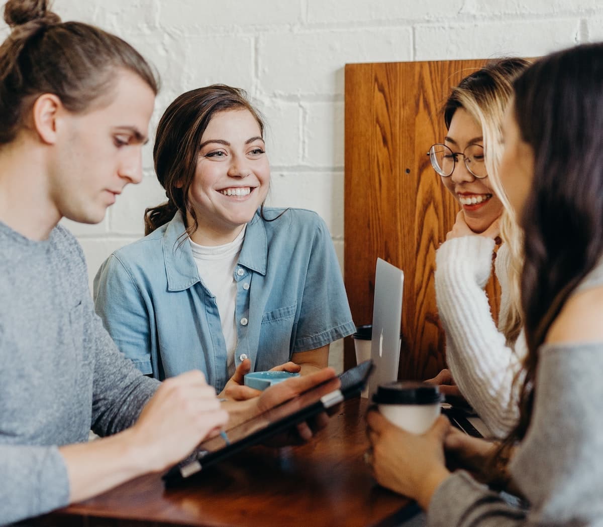 Four friends leaving Google reviews for a business on their mobile phones